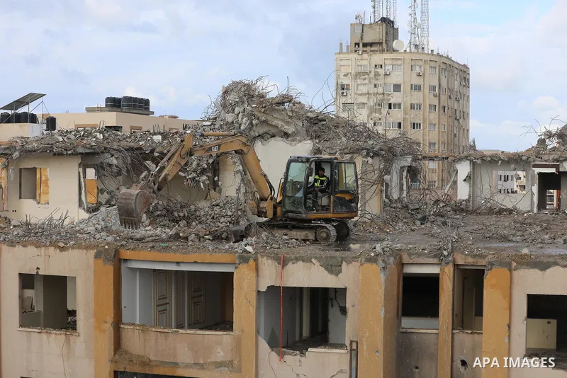 Palestinian workers remove the rubbles of al-Jawhara tower which was hit by Israeli strikes during the recent 11-day conflict between Israel and Hamas on May, in Gaza city on November 21, 2021. Photo by Ashraf Amra