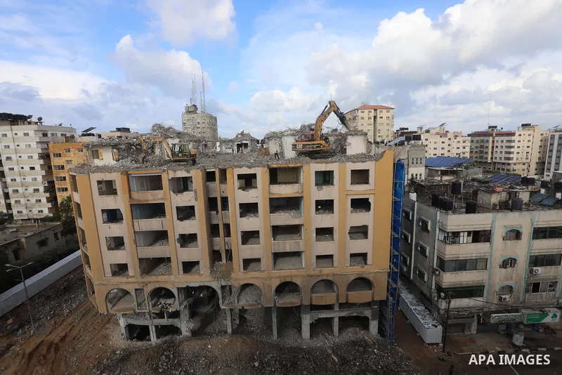 Palestinian workers remove the rubbles of al-Jawhara tower which was hit by Israeli strikes during the recent 11-day conflict between Israel and Hamas on May, in Gaza city on November 21, 2021. Photo by Ashraf Amra
