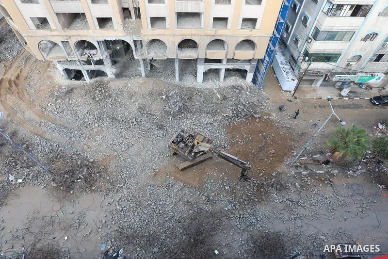 Palestinian workers remove the rubbles of al-Jawhara tower which was hit by Israeli strikes during the recent 11-day conflict between Israel and Hamas on May, in Gaza city on November 21, 2021. Photo by Ashraf Amra