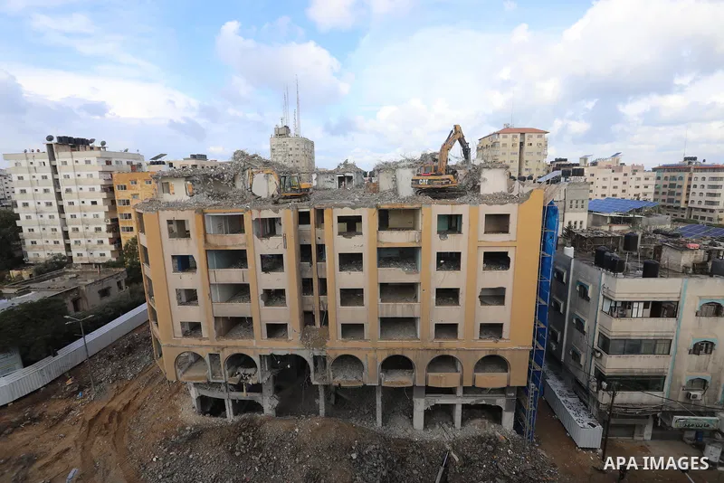 Palestinian workers remove the rubbles of al-Jawhara tower which was hit by Israeli strikes during the recent 11-day conflict between Israel and Hamas on May, in Gaza city on November 21, 2021. Photo by Ashraf Amra