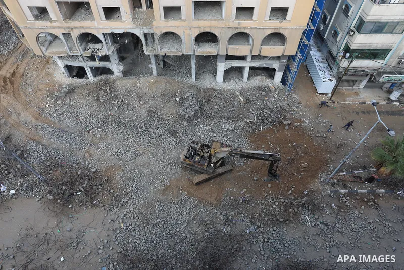 Palestinian workers remove the rubbles of al-Jawhara tower which was hit by Israeli strikes during the recent 11-day conflict between Israel and Hamas on May, in Gaza city on November 21, 2021. Photo by Ashraf Amra