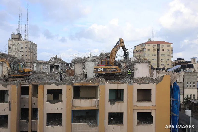 Palestinian workers remove the rubbles of al-Jawhara tower which was hit by Israeli strikes during the recent 11-day conflict between Israel and Hamas on May, in Gaza city on November 21, 2021. Photo by Ashraf Amra