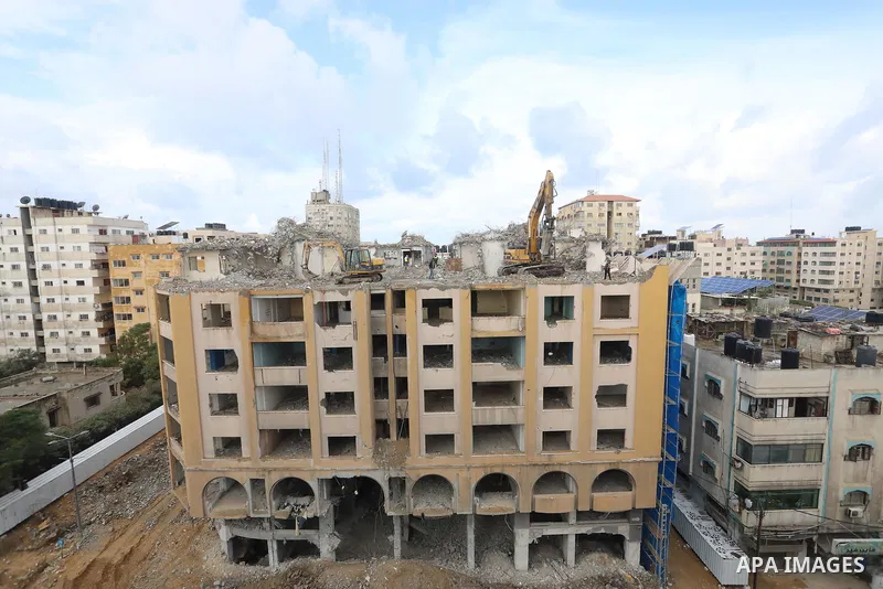 Palestinian workers remove the rubbles of al-Jawhara tower which was hit by Israeli strikes during the recent 11-day conflict between Israel and Hamas on May, in Gaza city on November 21, 2021. Photo by Ashraf Amra