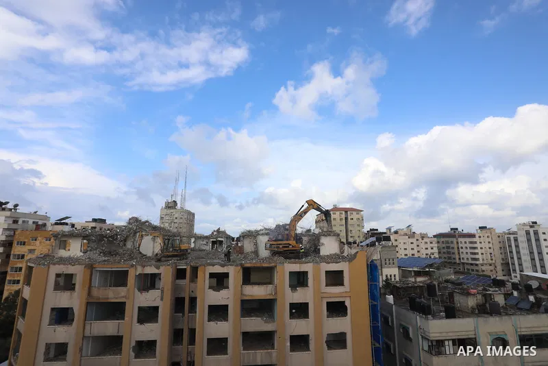 Palestinian workers remove the rubbles of al-Jawhara tower which was hit by Israeli strikes during the recent 11-day conflict between Israel and Hamas on May, in Gaza city on November 21, 2021. Photo by Ashraf Amra