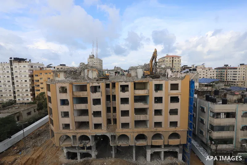 Palestinian workers remove the rubbles of al-Jawhara tower which was hit by Israeli strikes during the recent 11-day conflict between Israel and Hamas on May, in Gaza city on November 21, 2021. Photo by Ashraf Amra