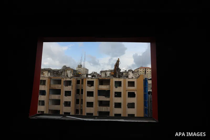 Palestinian workers remove the rubbles of al-Jawhara tower which was hit by Israeli strikes during the recent 11-day conflict between Israel and Hamas on May, in Gaza city on November 21, 2021. Photo by Ashraf Amra