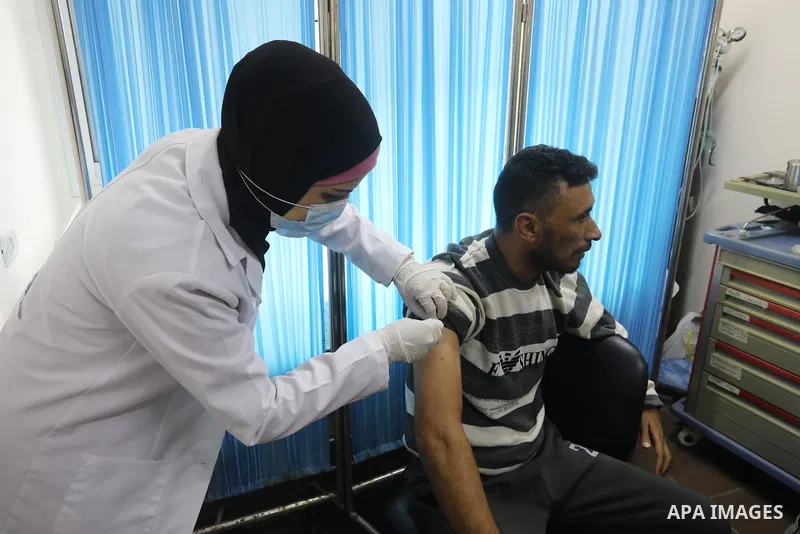 Palestinians get inoculated with a dose of the Covishield vaccine against the Covid-19 coronavirus, at a temporary vaccination centre set up, in Deir al-Balah in the center of Gaza Strip on November 211, 2021. Minister o...
