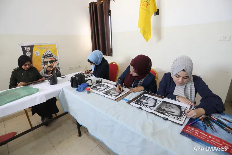 Palestinian graduates participate in a competition to draw the portrait of the death of late president Yasser Arafat, in Gaza city on November 211, 2021. Photo by Ashraf Amra