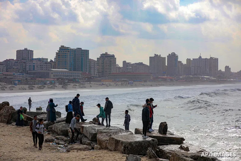 Palestians enjoy during a coldy day, at a beach in Gaza City 21 November 2021. The effects of the low pressure front which affected Palestine yesterday are expected to remain on Sunday, with a slight rise in temperature...