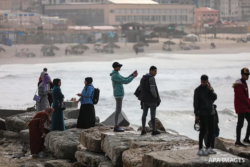 Palestians enjoy during a coldy day, at a beach in Gaza City 21 November 2021. The effects of the low pressure front which affected Palestine yesterday are expected to remain on Sunday, with a slight rise in temperature...