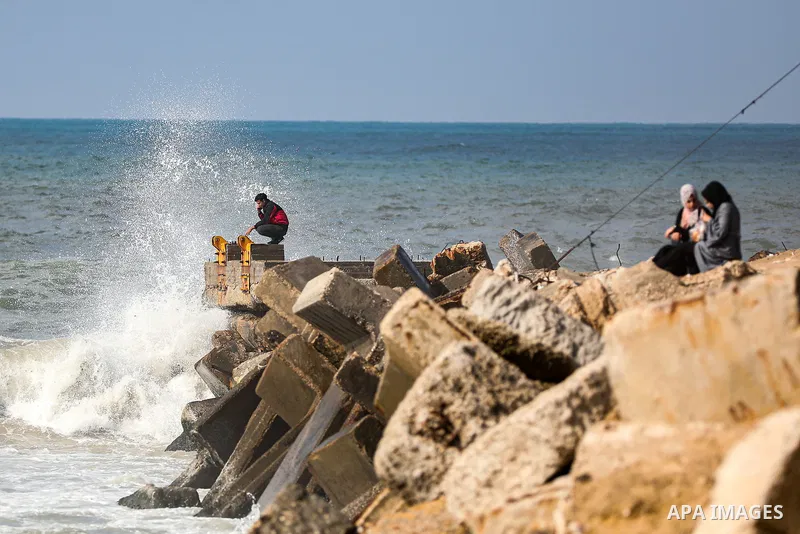 Palestians enjoy during a coldy day, at a beach in Gaza City 21 November 2021. The effects of the low pressure front which affected Palestine yesterday are expected to remain on Sunday, with a slight rise in temperature...