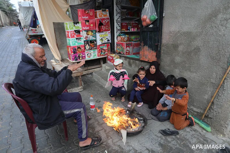Palestinians show as they in their daily lives during a rainy day, in Deir al-Balah in the center of Gaza strip on November 21, 2021. The effects of the low pressure front which affected Palestine yesterday are expected...
