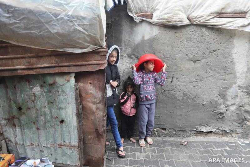 Palestinians show as they in their daily lives during a rainy day, in Deir al-Balah in the center of Gaza strip on November 21, 2021. The effects of the low pressure front which affected Palestine yesterday are expected...