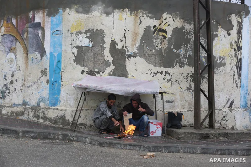 Palestinians show as they in their daily lives during a rainy day, in Deir al-Balah in the center of Gaza strip on November 21, 2021. The effects of the low pressure front which affected Palestine yesterday are expected...