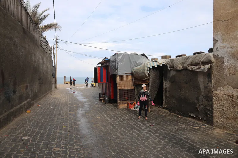 Palestinians show as they in their daily lives during a rainy day, in Deir al-Balah in the center of Gaza strip on November 21, 2021. The effects of the low pressure front which affected Palestine yesterday are expected...