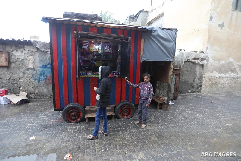 Palestinians show as they in their daily lives during a rainy day, in Deir al-Balah in the center of Gaza strip on November 21, 2021. The effects of the low pressure front which affected Palestine yesterday are expected...