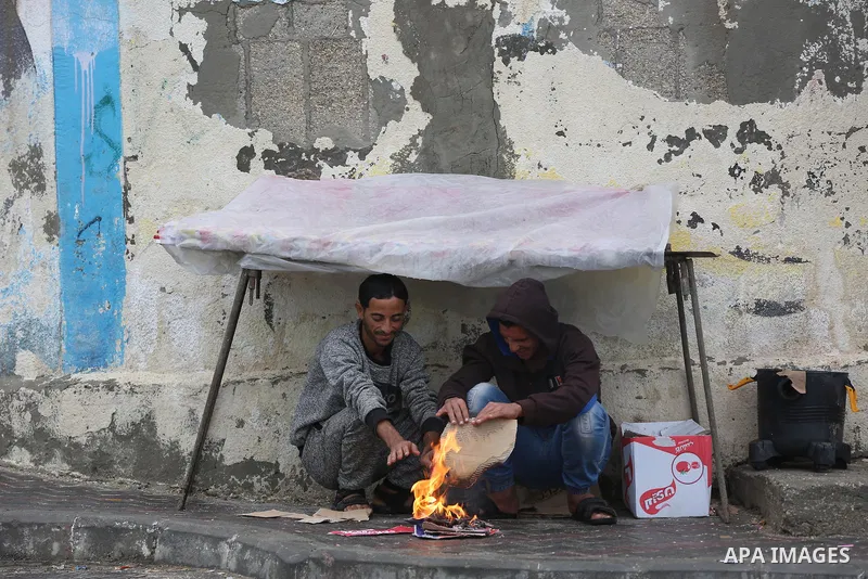 Palestinians show as they in their daily lives during a rainy day, in Deir al-Balah in the center of Gaza strip on November 21, 2021. The effects of the low pressure front which affected Palestine yesterday are expected...