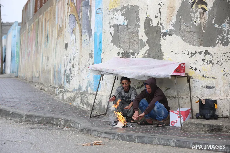 Palestinians show as they in their daily lives during a rainy day, in Deir al-Balah in the center of Gaza strip on November 21, 2021. The effects of the low pressure front which affected Palestine yesterday are expected...