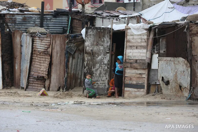 Palestinians show as they in their daily lives during a rainy day, in Deir al-Balah in the center of Gaza strip on November 21, 2021. The effects of the low pressure front which affected Palestine yesterday are expected...