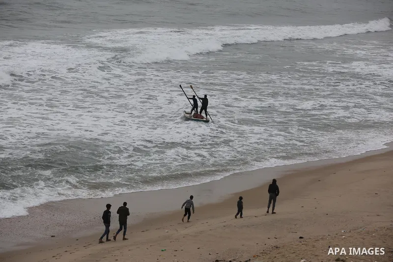 Palestinians show as they in their daily lives during a rainy day, in Deir al-Balah in the center of Gaza strip on November 21, 2021. The effects of the low pressure front which affected Palestine yesterday are expected...