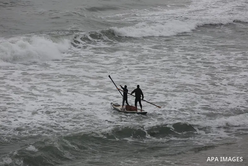 Palestinians show as they in their daily lives during a rainy day, in Deir al-Balah in the center of Gaza strip on November 21, 2021. The effects of the low pressure front which affected Palestine yesterday are expected...