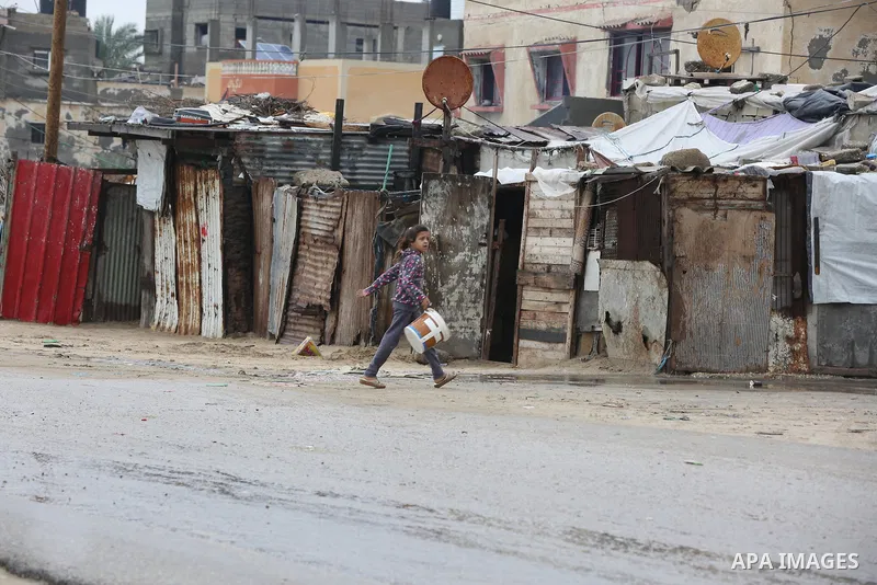 Palestinians show as they in their daily lives during a rainy day, in Deir al-Balah in the center of Gaza strip on November 21, 2021. The effects of the low pressure front which affected Palestine yesterday are expected...