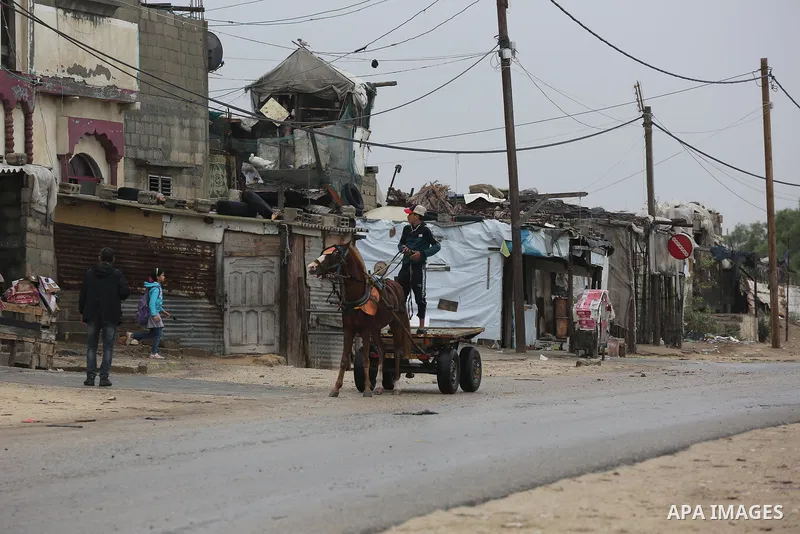 Palestinians show as they in their daily lives during a rainy day, in Deir al-Balah in the center of Gaza strip on November 21, 2021. The effects of the low pressure front which affected Palestine yesterday are expected...