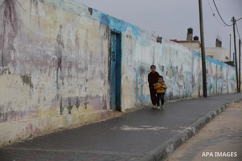 Palestinians show as they in their daily lives during a rainy day, in Deir al-Balah in the center of Gaza strip on November 21, 2021. The effects of the low pressure front which affected Palestine yesterday are expected...