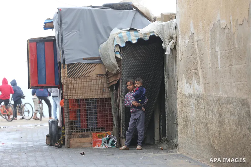 Palestinians show as they in their daily lives during a rainy day, in Deir al-Balah in the center of Gaza strip on November 21, 2021. The effects of the low pressure front which affected Palestine yesterday are expected...