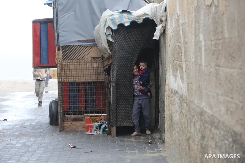 Palestinians show as they in their daily lives during a rainy day, in Deir al-Balah in the center of Gaza strip on November 21, 2021. The effects of the low pressure front which affected Palestine yesterday are expected...