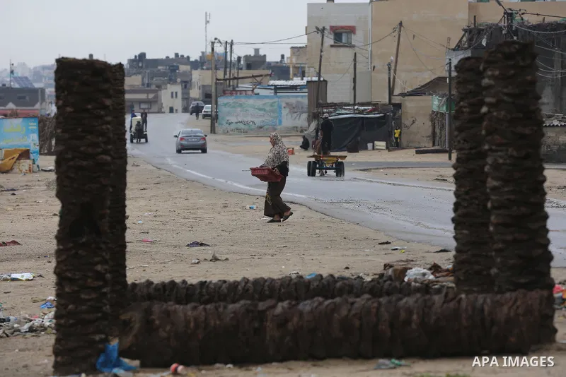 Palestinians show as they in their daily lives during a rainy day, in Deir al-Balah in the center of Gaza strip on November 21, 2021. The effects of the low pressure front which affected Palestine yesterday are expected...