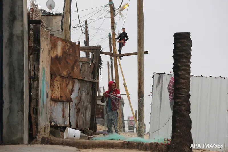Palestinians show as they in their daily lives during a rainy day, in Deir al-Balah in the center of Gaza strip on November 21, 2021. The effects of the low pressure front which affected Palestine yesterday are expected...