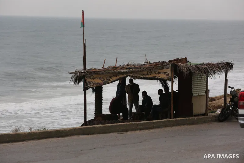 Palestinians show as they in their daily lives during a rainy day, in Deir al-Balah in the center of Gaza strip on November 21, 2021. The effects of the low pressure front which affected Palestine yesterday are expected...