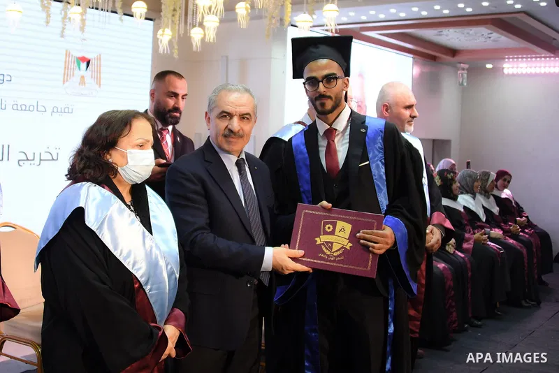 Palestinian Prime Minister Mohammed Ishtayeh participates in the graduation ceremony of the first cohort of Nablus University for Vocational and Technical Education, in the West Bank city of Ramallah, on November 21, 202...