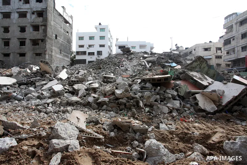 Palestinian workers remove the rubbles of a building which was hit by Israeli strikes during the recent 11-day conflict between Israel and Hamas on May, in Gaza city on November 22, 2021. Qatar and Egypt have signed agre...