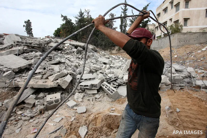 Palestinian workers remove the rubbles of a building which was hit by Israeli strikes during the recent 11-day conflict between Israel and Hamas on May, in Gaza city on November 22, 2021. Qatar and Egypt have signed agre...