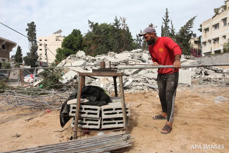 Palestinian workers remove the rubbles of a building which was hit by Israeli strikes during the recent 11-day conflict between Israel and Hamas on May, in Gaza city on November 22, 2021. Qatar and Egypt have signed agre...
