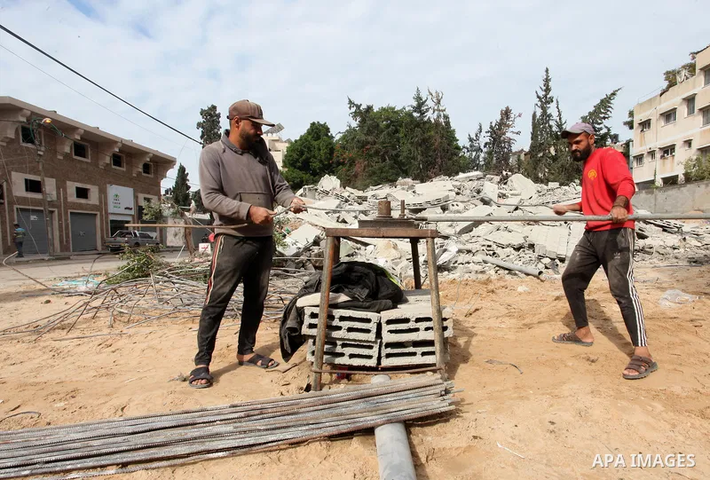 Palestinian workers remove the rubbles of a building which was hit by Israeli strikes during the recent 11-day conflict between Israel and Hamas on May, in Gaza city on November 22, 2021. Qatar and Egypt have signed agre...
