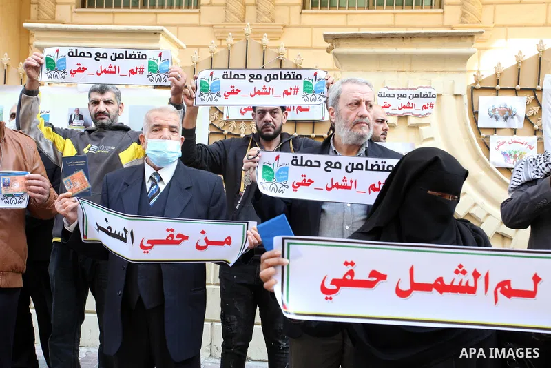 Palestinians hold IDs and banners to demand of the family reunification in front of the headquarter United Nation "UNSCO" in Gaza city, on 22 November 2021. Thousands of Palestinians have suffered as a result of the law,...
