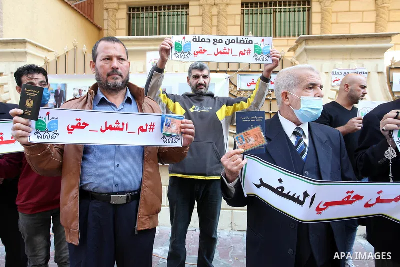 Palestinians hold IDs and banners to demand of the family reunification in front of the headquarter United Nation "UNSCO" in Gaza city, on 22 November 2021. Thousands of Palestinians have suffered as a result of the law,...