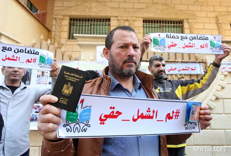 Palestinians hold IDs and banners to demand of the family reunification in front of the headquarter United Nation "UNSCO" in Gaza city, on 22 November 2021. Thousands of Palestinians have suffered as a result of the law,...