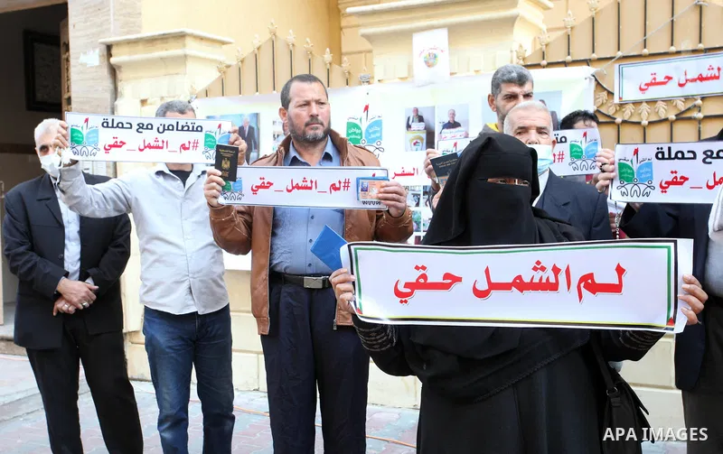 Palestinians hold IDs and banners to demand of the family reunification in front of the headquarter United Nation "UNSCO" in Gaza city, on 22 November 2021. Thousands of Palestinians have suffered as a result of the law,...