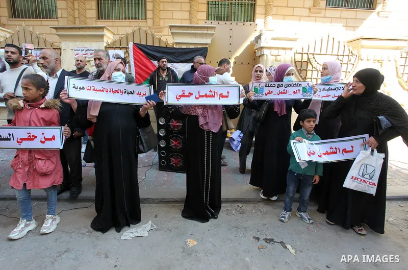 Palestinians hold IDs and banners to demand of the family reunification in front of the headquarter United Nation "UNSCO" in Gaza city, on 22 November 2021. Thousands of Palestinians have suffered as a result of the law,...