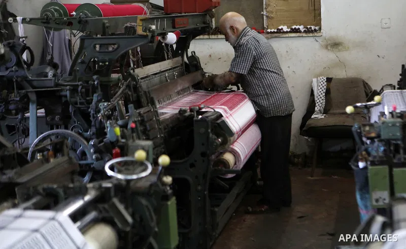 A Palestinian man works at a Keffiyeh textile factory in the West Bank City of Hebron, on November 22, 2021. Keffiyeh is black-and-white chequered scarf is a traditional Arabian headdress. Photo by Mamoun Wazwaz