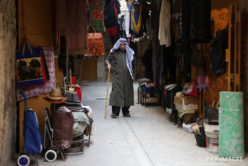 A Palestinian man wearing Keffiyeh walks at a street in the West Bank City of Hebron, on November 22, 2021. Keffiyeh is black-and-white chequered scarf is a traditional Arabian headdress. Photo by Mamoun Wazwaz
