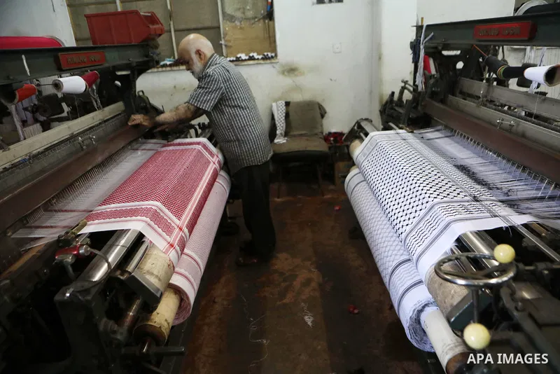A Palestinian man works at a Keffiyeh textile factory in the West Bank City of Hebron, on November 22, 2021. Keffiyeh is black-and-white chequered scarf is a traditional Arabian headdress. Photo by Mamoun Wazwaz