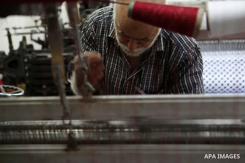 A Palestinian man works at a Keffiyeh textile factory in the West Bank City of Hebron, on November 22, 2021. Keffiyeh is black-and-white chequered scarf is a traditional Arabian headdress. Photo by Mamoun Wazwaz
