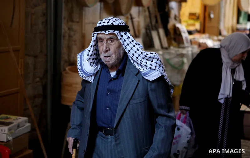 A Palestinian man wearing Keffiyeh walks at a street in the West Bank City of Hebron, on November 22, 2021. Keffiyeh is black-and-white chequered scarf is a traditional Arabian headdress. Photo by Mamoun Wazwaz