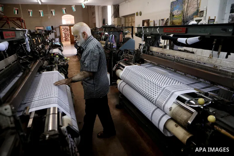 A Palestinian man works at a Keffiyeh textile factory in the West Bank City of Hebron, on November 22, 2021. Keffiyeh is black-and-white chequered scarf is a traditional Arabian headdress. Photo by Mamoun Wazwaz