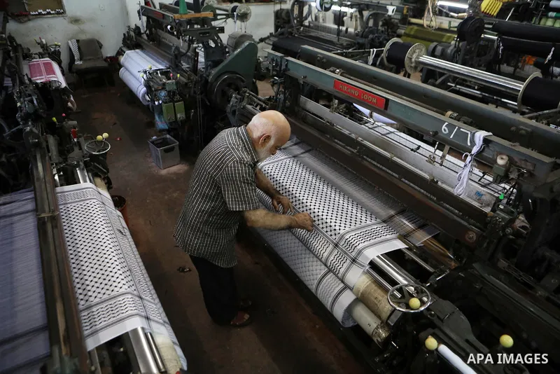 A Palestinian man works at a Keffiyeh textile factory in the West Bank City of Hebron, on November 22, 2021. Keffiyeh is black-and-white chequered scarf is a traditional Arabian headdress. Photo by Mamoun Wazwaz